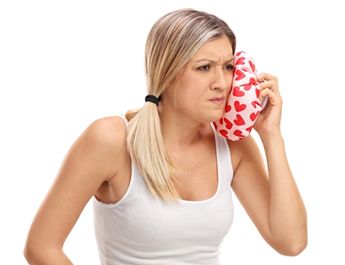 woman applying cold compress to face