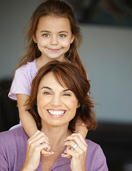 Mother and young daughter with red hair smiling