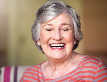 Senior woman enjoying the benefits of her dentures and smiling