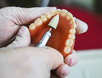 Lab tech filing dentures