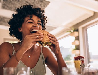 Young woman about to bite into a sandwich 