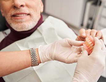 Dentist showing a patient a set of dentures