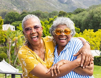 Two women hugging and smiling outside