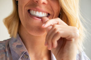 Close up of woman snugly inserting Invisalign tray